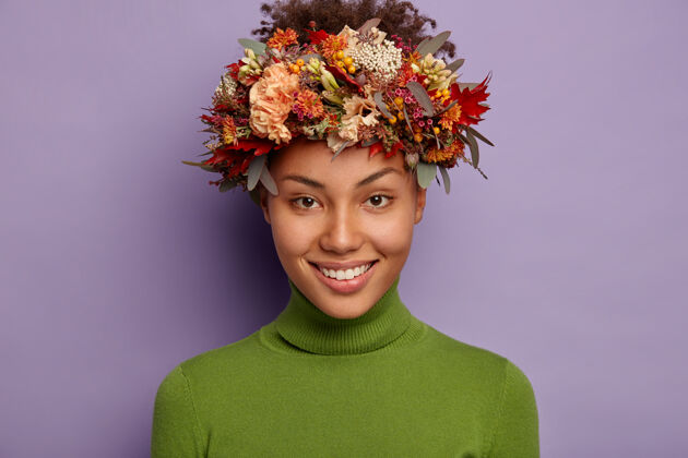 室内美丽黑皮肤女性的肖像笑容可掬 戴着秋花做的花环年轻情感女人