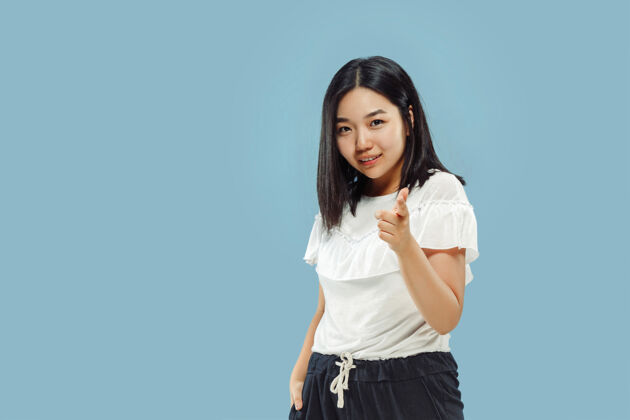 邀请蓝色空间上的韩国年轻女子半身像穿白衬衫的女模特展示并指向某物手势韩语衬衫