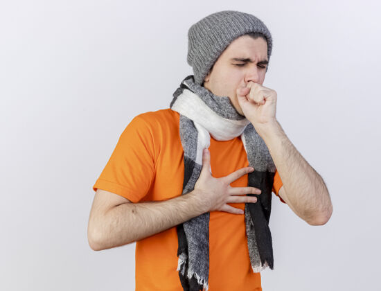 冬天咳嗽的年轻病人戴着冬天的帽子戴着围巾把手放在嘴上隔离在白色手放围巾