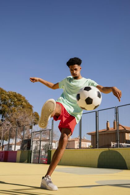 足球运动员一个正在踢足球的年轻人年轻人足球男人