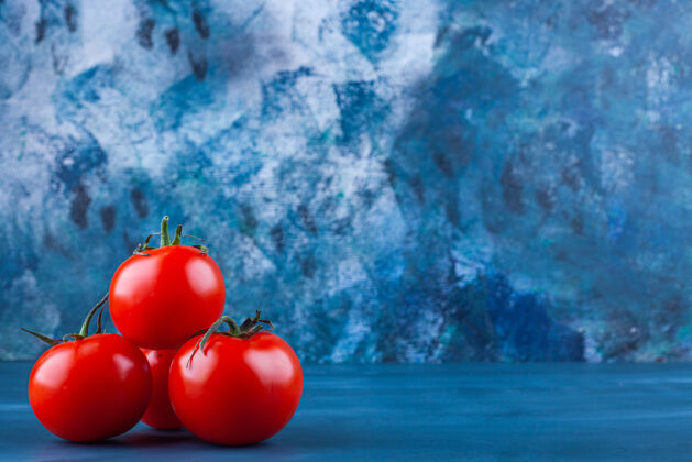 新鲜健康的红色新鲜西红柿放在蓝色的表面蔬菜食用番茄