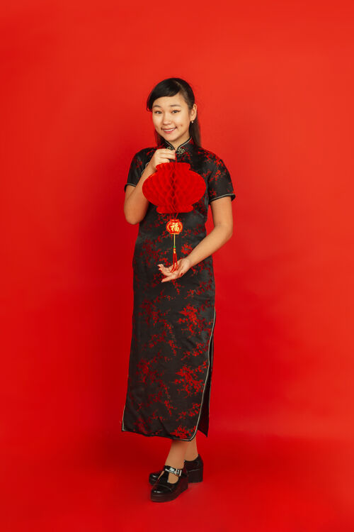 传统新年快乐红色背景上孤立的亚洲少女肖像穿着传统服装的女模特看起来很开心 带着装饰微笑庆祝 节日 情感肖像喜悦微笑