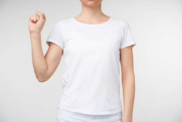 女性一张剪下来的照片 年轻女性穿着基本的白色t恤 紧握着她的手 同时用手语显示字母s 站在白色背景上站立室内身体