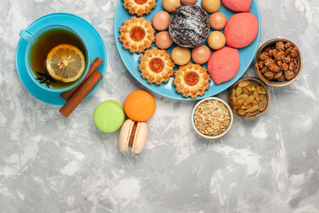 饼干俯瞰一杯茶 白色表面有法国麦卡龙饼干和蛋糕糖果饮食水果