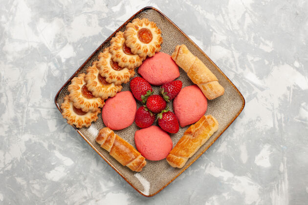 食物白色桌面上有美味的百吉饼 蛋糕 新鲜草莓和饼干糖桌子派