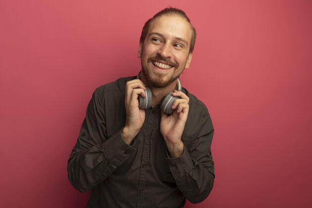 年轻一个穿着灰色衬衫戴着耳机的年轻帅哥在一旁开心地微笑着男人加油粉色