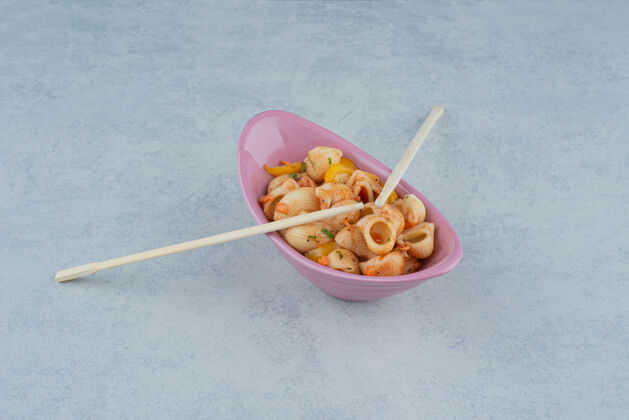 筷子美味的粉红色盘子 配通心粉和筷子 深色背景高品质照片吃美味意大利面
