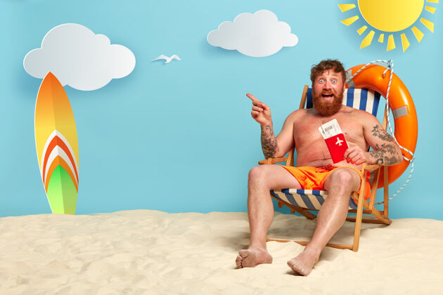 男性赤裸上身留胡子的红发男人在海滩上摆姿势赤膊上阵救生圈短裤