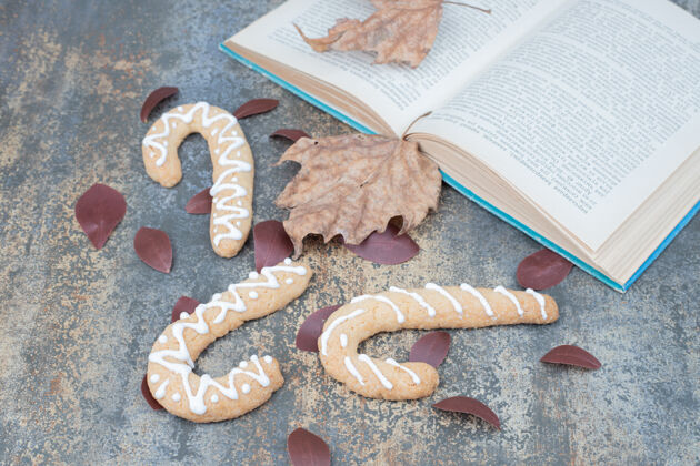 糕点姜饼曲奇和打开的书上的叶子大理石表面高品质的照片美味庆祝甜点