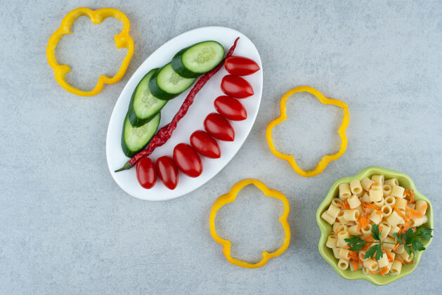 胡椒白色盘子上的蔬菜沙拉和大理石背景上的通心粉高品质照片卷心菜蔬菜番茄
