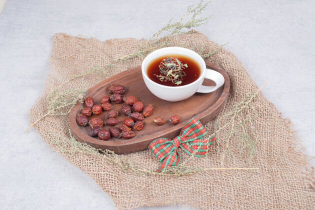 杯一杯茶和干蔓越莓放在粗麻布上高质量的照片蔓越莓粗麻布草药