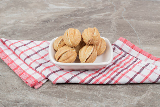 饼干一碗核桃形状的饼干放在桌布上高质量的照片甜点美食面包房