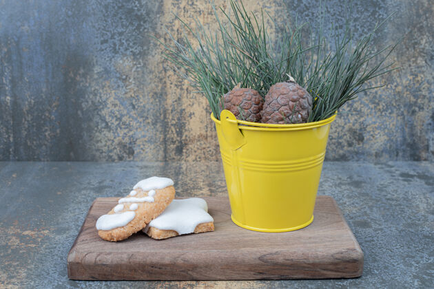 桶姜饼饼干和松果放在木板上高质量的照片节日糕点饼干