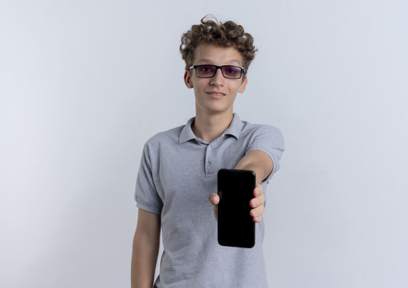 手机戴着黑眼镜 穿着灰色马球衫的年轻人站在白墙上微笑着穿眼镜男人