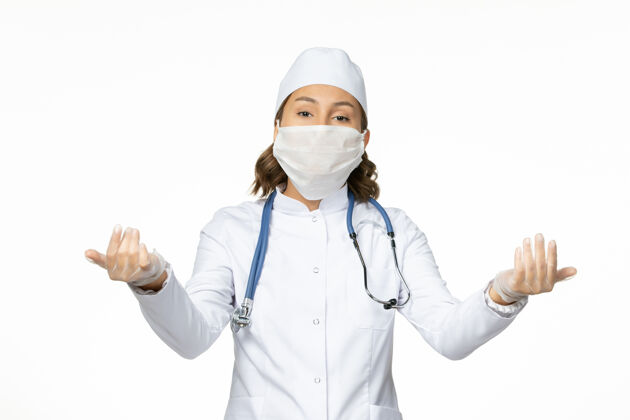 药品白色办公桌上戴着无菌口罩和手套的年轻女医生到期正面手套