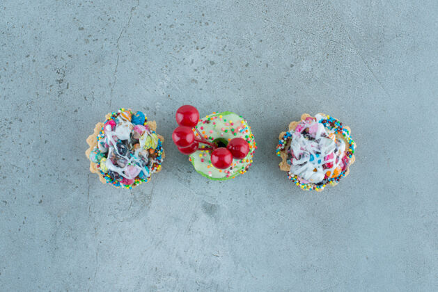 纸杯蛋糕在大理石背景上 有糖果填充和小甜甜圈的纸杯蛋糕高品质照片口感糖果烘焙