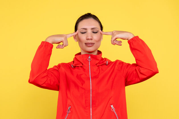 运动正面图穿红色外套的年轻女性在黄色背景上思考运动员情感观点