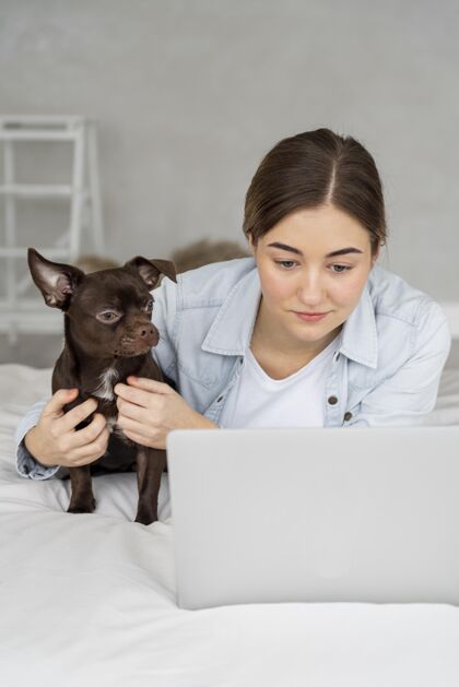狗床上有笔记本电脑和狗的中枪女孩责任青少年女孩