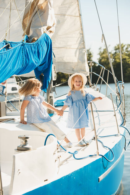 水手孩子们在海上游艇上青少年或儿童女孩在户外五颜六色的衣服儿童时尚 阳光明媚的夏天 河流和假日的概念巡航家庭享受