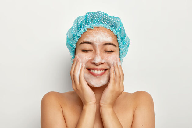 日本人欢喜少女模特写真应用泡沫洁面乳 触碰脸颊 拥有完美清新洁净的沐浴后肌肤 清洁毛孔面部健康微笑