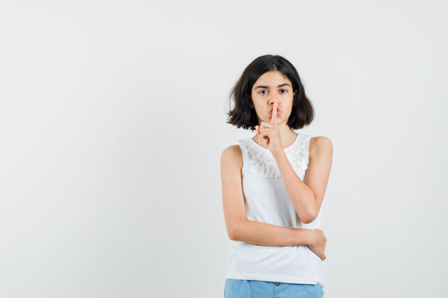 肖像小女孩在白色上衣 短裤里表现出沉默的姿态 看上去很小心前视图青少年人衬衫