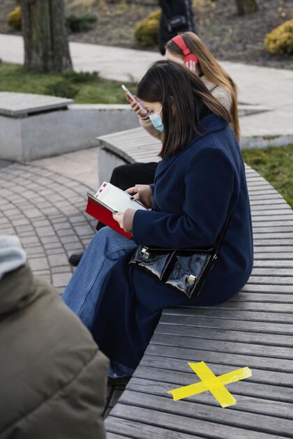 冠状病毒坐在远处戴着面具的人防护技术耳机