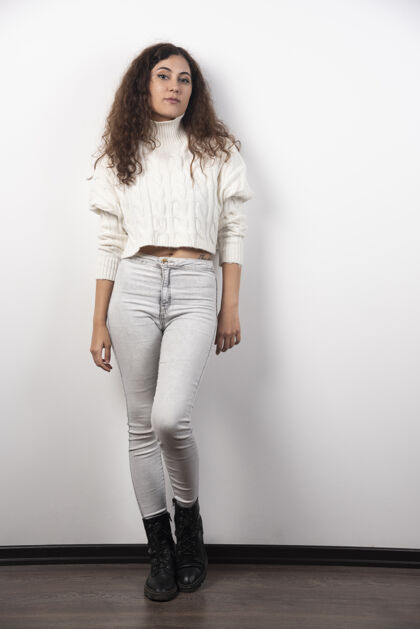 长相穿着白色毛衣的年轻女子站在白色的墙上高质量的照片人青少年女性