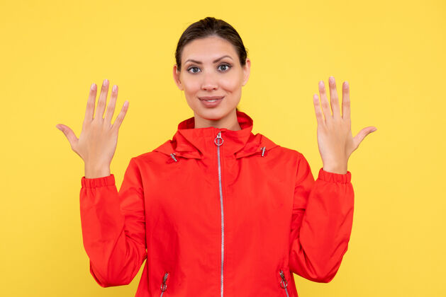 外套正面图黄色背景上穿着红色外套的年轻女性情绪运动专业