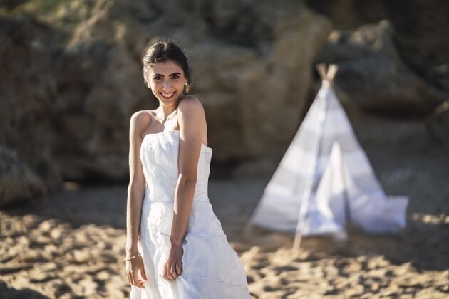 情侣黑发白人新娘微笑着在海滩上摆姿势大海成人新娘
