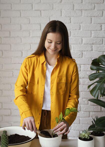 植物学穿黄衬衫的女人在室内园艺生态室内女人室内植物