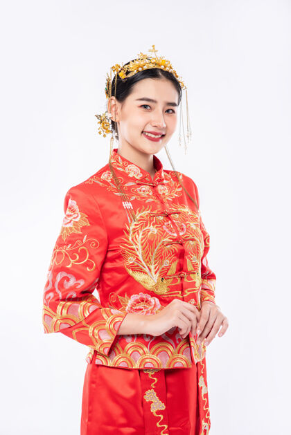 中国新年穿旗袍套装的女人微笑着迎接过年购物的旅客中国文化文化中国民族