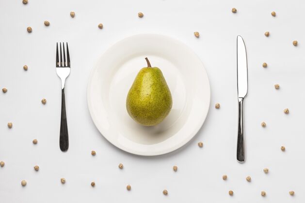 顶视图把新鲜的梨平放在盘子里和餐具一起农产品料理健康