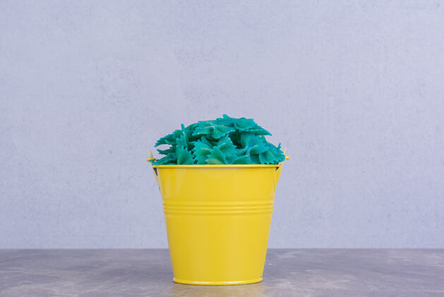 食物蓝色的意大利面放在黄色的金属桶里容器传统产品
