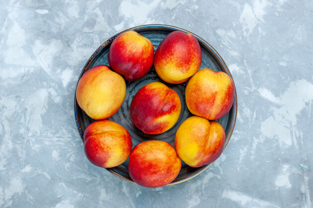 生的在浅白色的桌子上俯瞰新鲜的桃子和美味的夏日水果水果食物甜