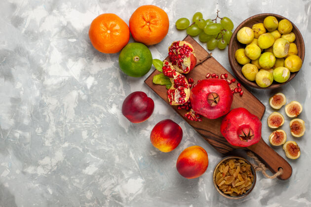 水果白色书桌上有新鲜的无花果和石榴 桃子和葡萄顶部农产品葡萄