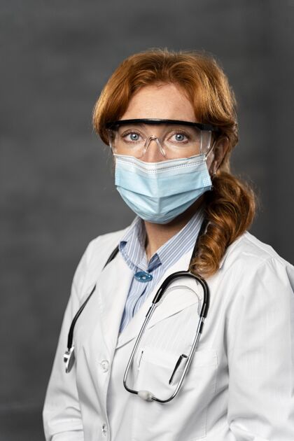 女人带医用面罩 听诊器和护目镜的女医生正面图全科医生工作职业