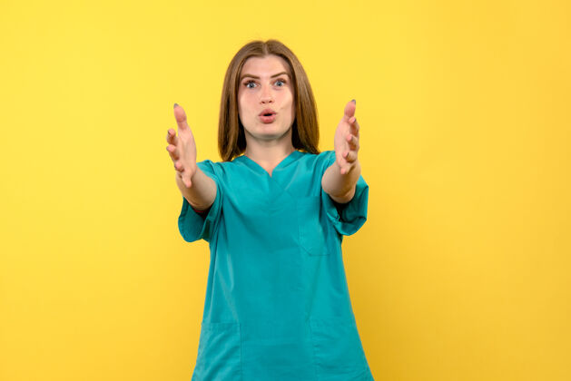 护士正面图：女医生在黄色空间摆姿势肖像女人脸