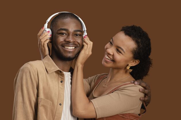 耳机戴着耳机的快乐笑脸夫妇的画像黑人女人女人男人