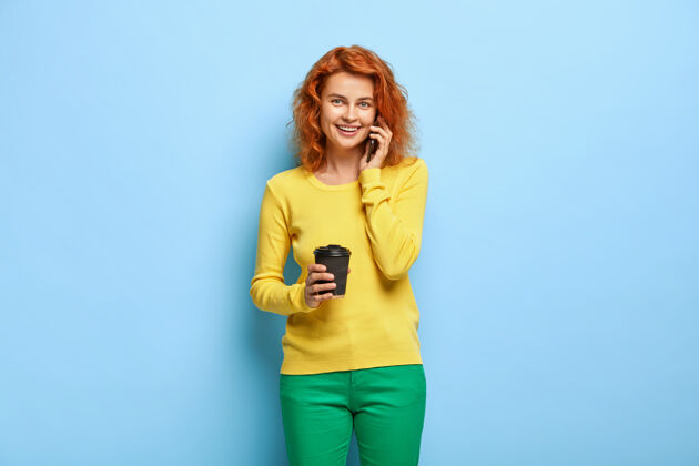 毛衣可爱的狐狸女人的肖像喝咖啡 通过智能手机打电话交谈休闲狐狸