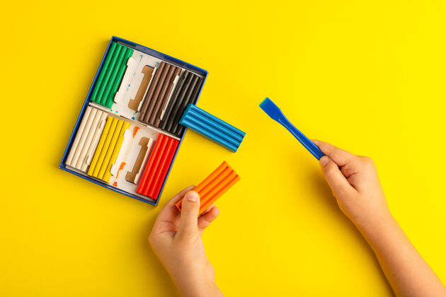 教育顶视图彩色橡皮泥儿童工作和玩它的黄色墙上彩色照片儿童学校画笔彩色工作