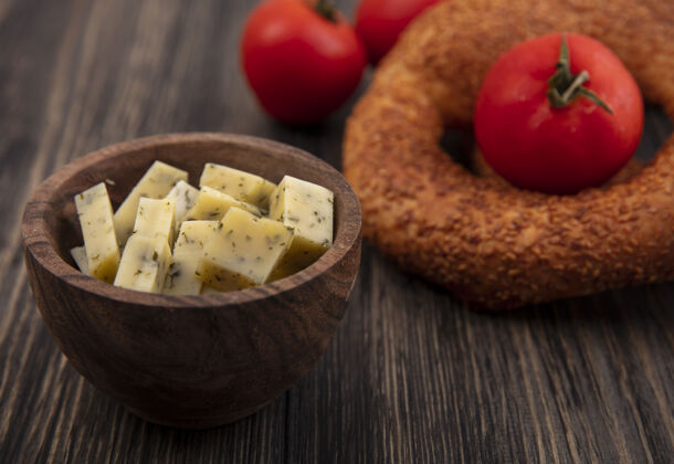 切片木制背景上有切碎的奶酪片和西红柿的木碗顶视图风景碗西红柿