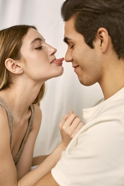 男人侧视图拥抱笑脸夫妇与妇女伸出舌头关闭女人对