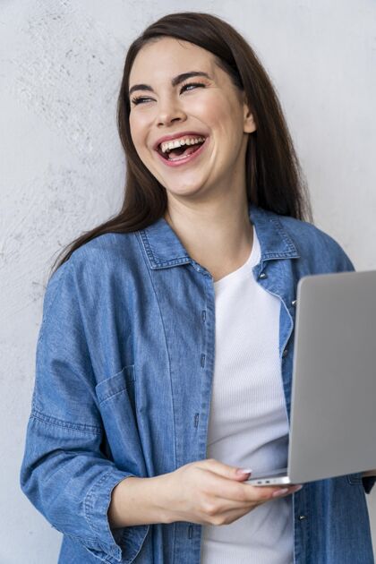 国际使用笔记本电脑的快乐大笑女人的画像全球全球女人
