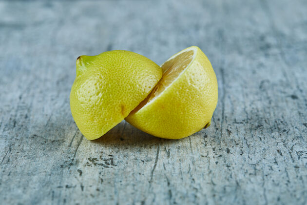 成熟多汁的半切黄色柠檬在大理石表面多汁切片酸