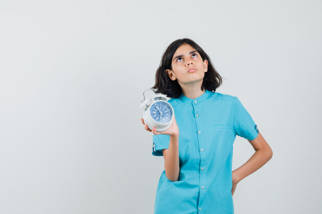 青少年学生女孩展示时钟 穿着蓝色衬衫思考 看起来很专注人持有关注