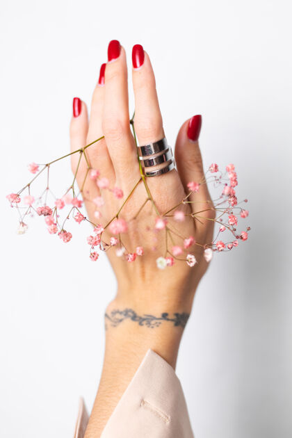 博客柔美温柔的照片 女人手上戴着大戒指 红色的指甲 手上拿着可爱的粉色干花植物叶美丽