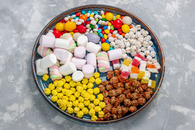 美味顶视图糖果组成不同颜色的糖果与棉花糖在浅白的办公桌糖糖果邦邦甜的壁橱邦邦视野糖果