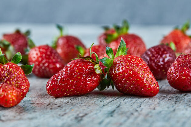 成熟新鲜的红色草莓放在大理石表面叶水果新鲜