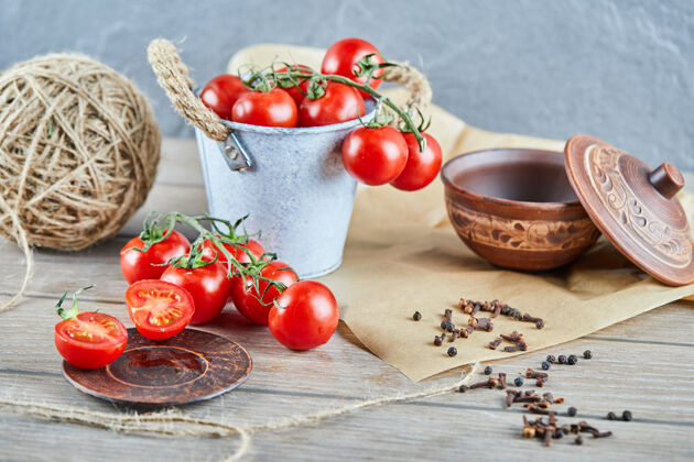 碗木桌上放着一桶西红柿和半切的西红柿熟桶维生素