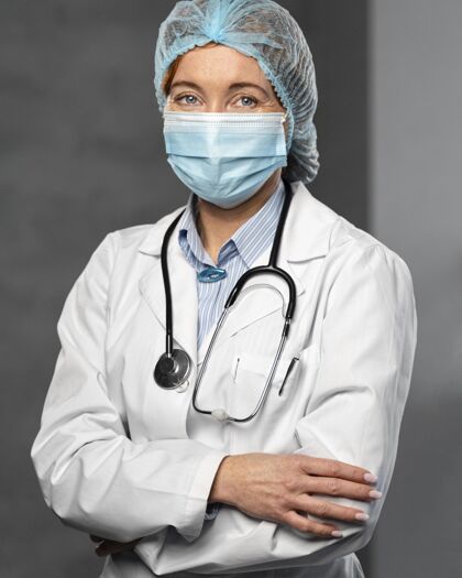 卫生工作者带医用面罩 听诊器和发网的女医生的正面图医学听诊器面罩